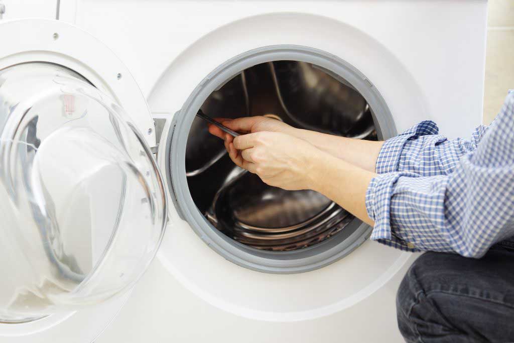 Appliance repair technician fixing a dryer