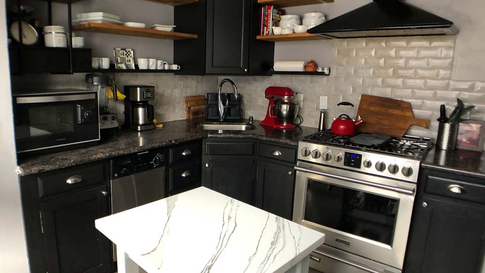 A kitchen with granite countertops and a stainless steel oven