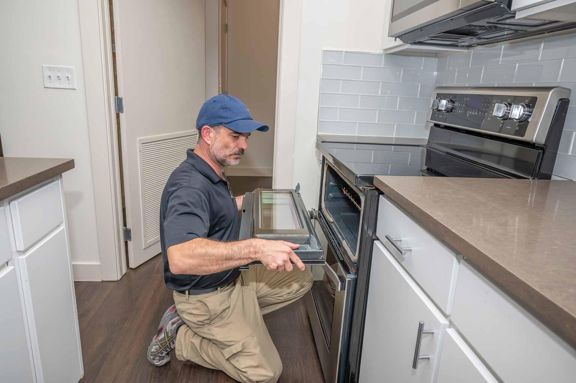 Appliance repair technician working on an oven